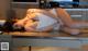 A woman laying on top of a desk in a kitchen.