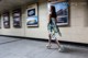 A woman in a dress is walking through a subway station.