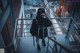 A woman standing on a stairway talking on a cell phone.