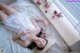 A woman laying on a bed with flowers in her hair.