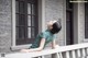 A woman leaning on a railing looking up at the sky.